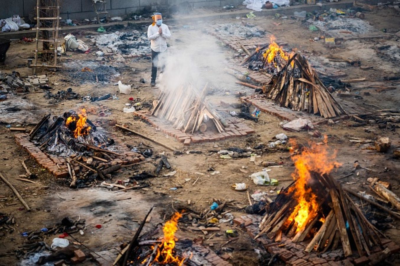 A Man Prays Next To A Burning Pyre Of A Victim Who Died Of The Covid-19 Coronavirus At A Cremation Ground In New Delhi. Photo: Jewel Samad/ Afp Via Getty Images