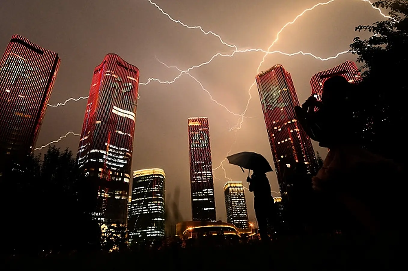 A Bolt Of Lightning Crosses The Sky As People Look At Buildings Displaying A Light Show On The Eve Of The 100Th Anniversary Of The Chinese Communist Party In Beijing. Photo: Noel Celis/Afp Via Getty Images