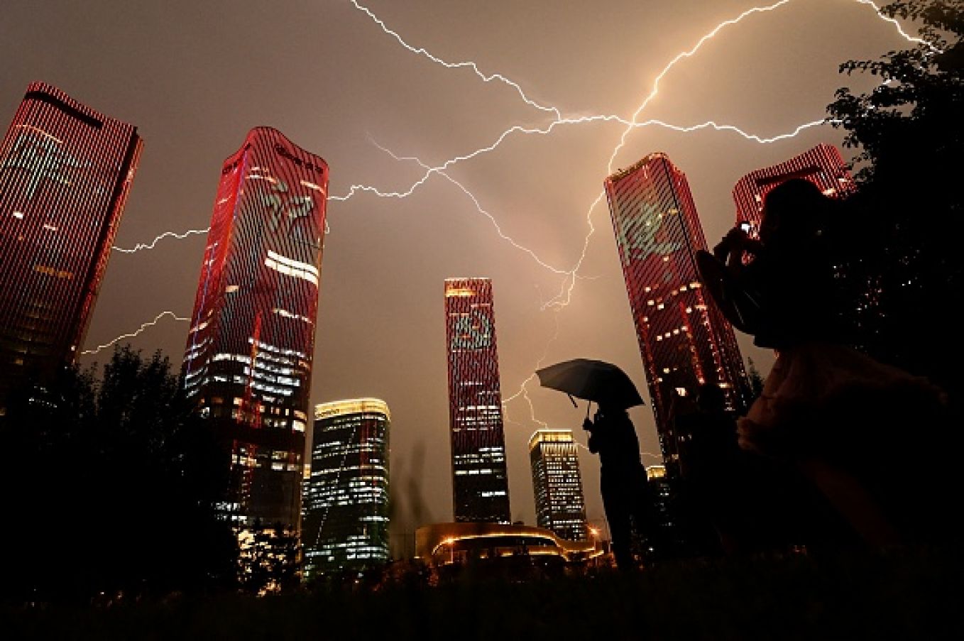 A Bolt Of Lightning Crosses The Sky As People Look At Buildings Displaying A Light Show On The Eve Of The 100Th Anniversary Of The Chinese Communist Party In Beijing. Photo: Noel Celis/Afp Via Getty Images