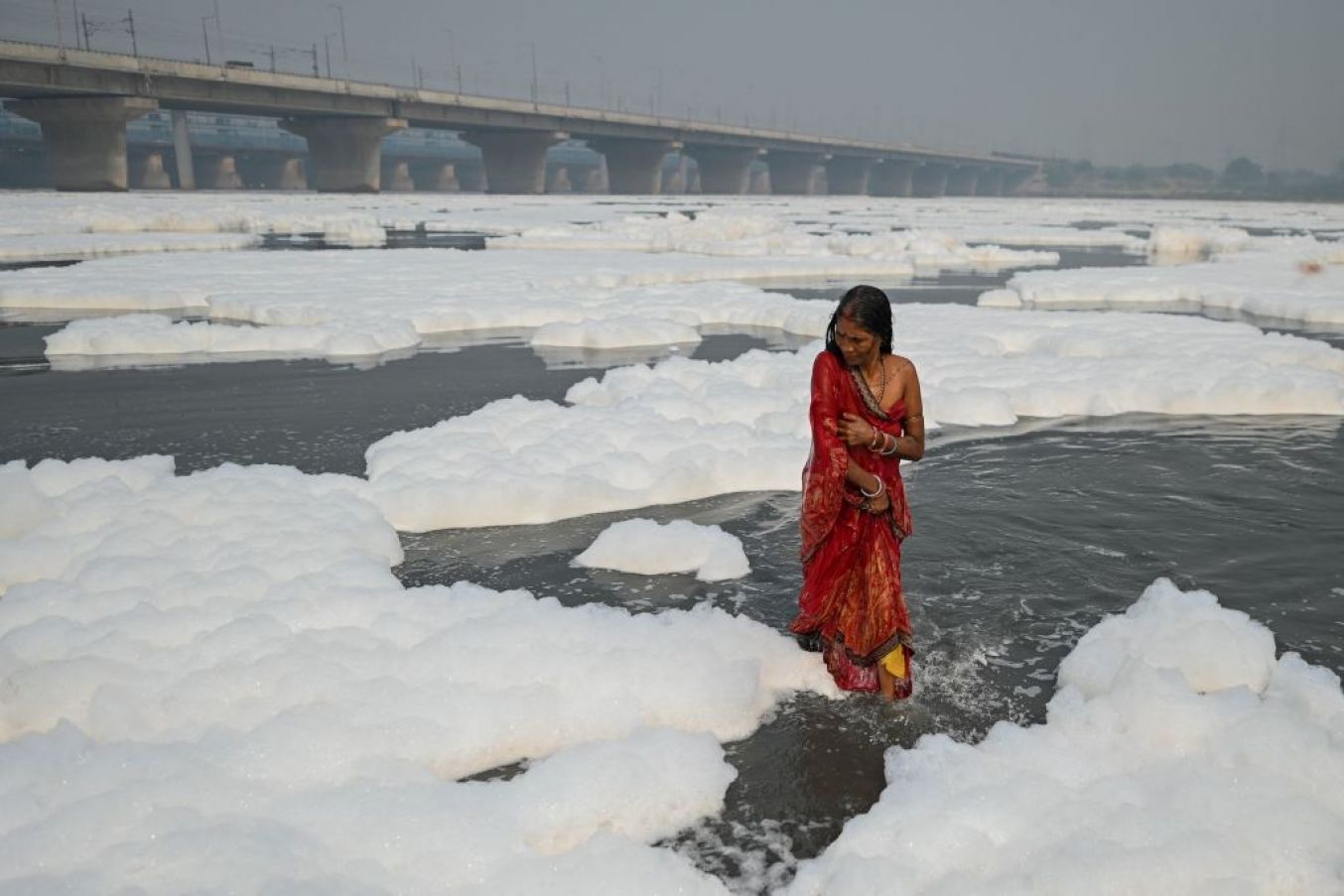 A Hindu Devotee Takes A Dip In The Yamuna River Amid Foam Created By Pollution In The Water In New Delhi. Photo: Sajjad Hussain/ Afp Via Getty Images