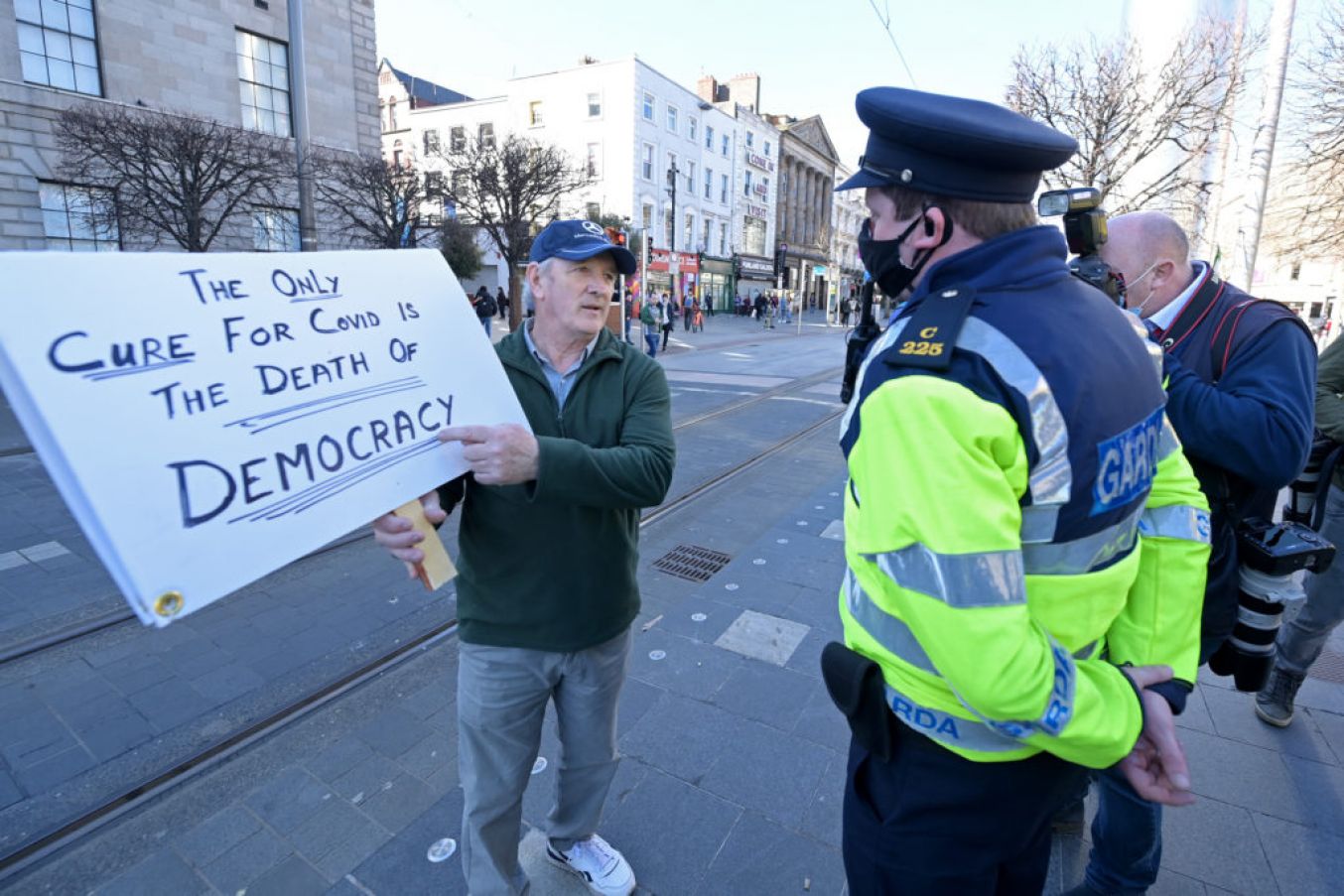 A Garda Speaks With A Man Holding Up A Banner As Anti-Lockdown Protesters Demonstrate On St Patrick's Day In Dublin. Photo: Charles Mcquillan/Getty