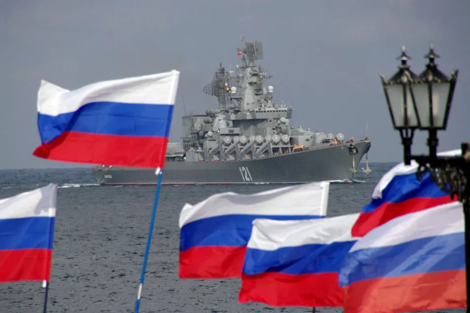 People wave Russian flags as the Moskva warship enters Sevastopol bay