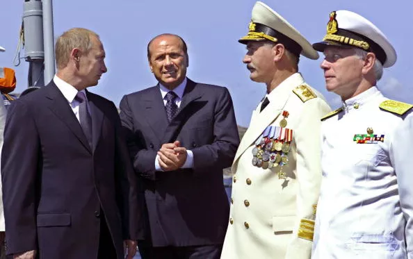 Vladimir Putin and Italian prime minister Silvio Berlusconi greet two naval captains onboard the Moskva warship