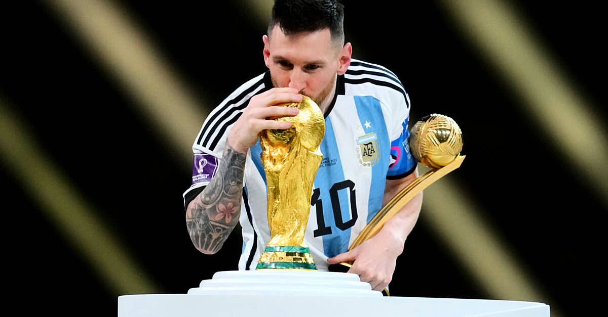 Lionel Messi Kisses His Trophy While Celebrating Win at FIFA World