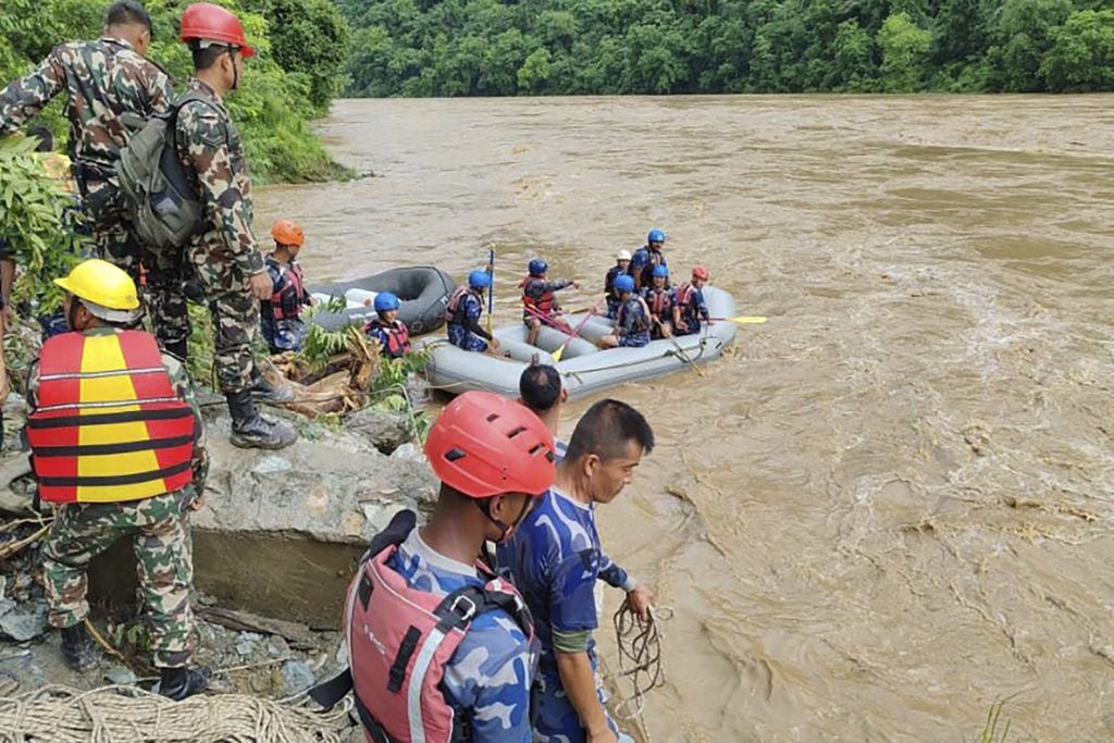 Two buses carrying more than 50 people swept into river by landslide in Nepal