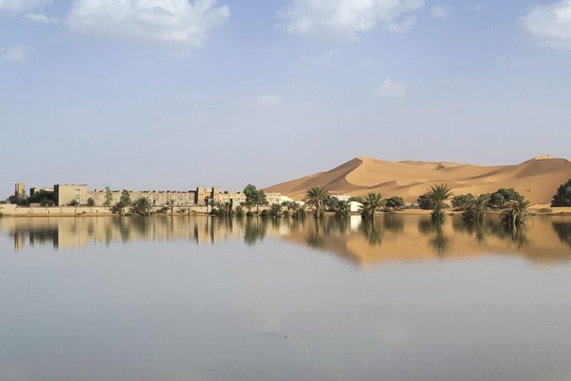 Water Gushes Through Palm Trees And Sand Dunes After Rare Rain In Sahara Desert