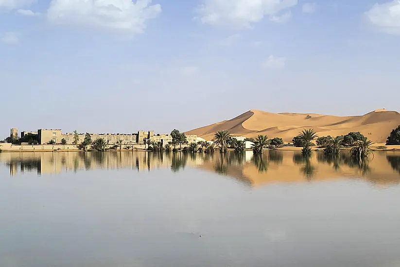 Water Gushes Through Palm Trees And Sand Dunes After Rare Rain In Sahara Desert