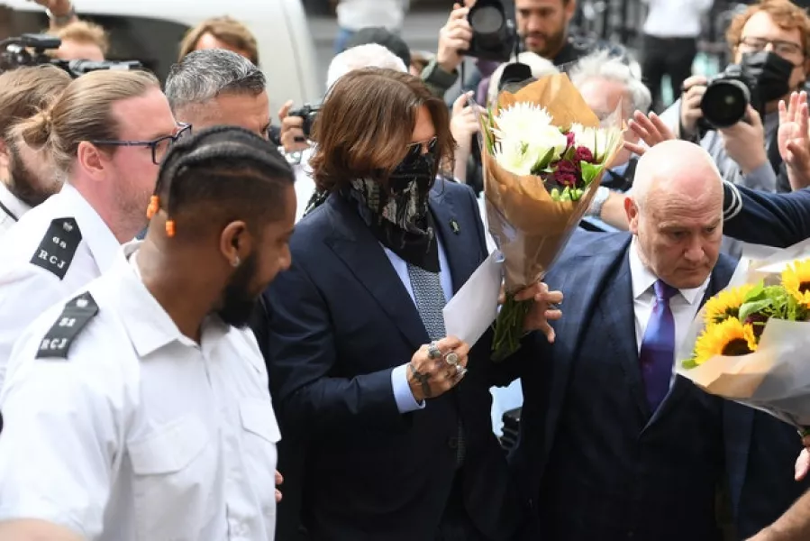 Actor Johnny Depp receives flowers as he arrives at the High Court in London (Kirsty O’Connor/PA)
