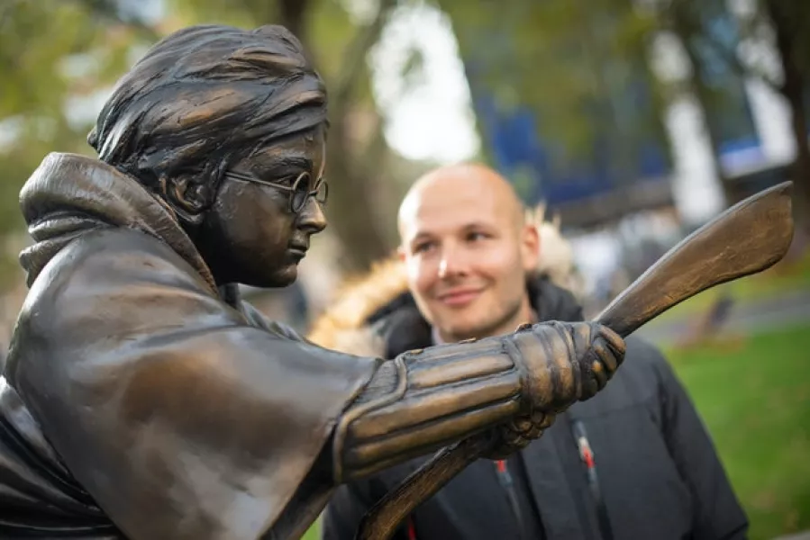 A fan looks at the new Harry Potter statue in Leicester Square (Dominic Lipinski/PA)