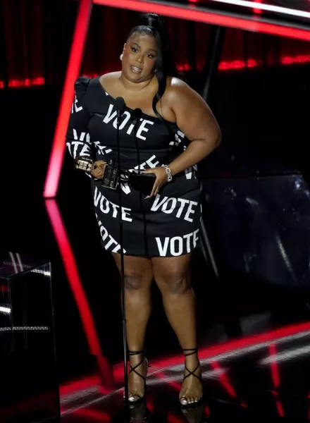 Lizzo won top song sales artist and stole the show in an eye-catching ‘vote’ dress before delivering a rousing acceptance speech (AP Photo/Chris Pizzello)