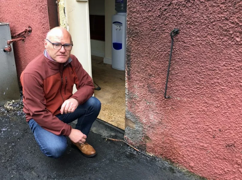 West Belfast MP Paul Maskey inspects the damage after an arson and paint bomb attack on Sinn Fein offices at Connolly House in August 2018 (David Young/PA)