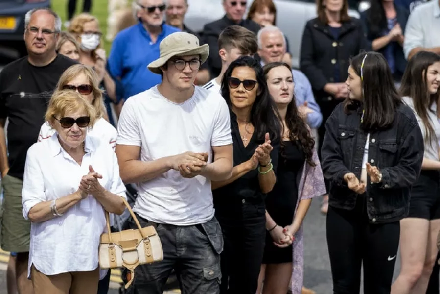 Local people turn out to applaud as the coffin of former television presenter Brian Black passes through the village of Strangford (Liam McBurney/PA)