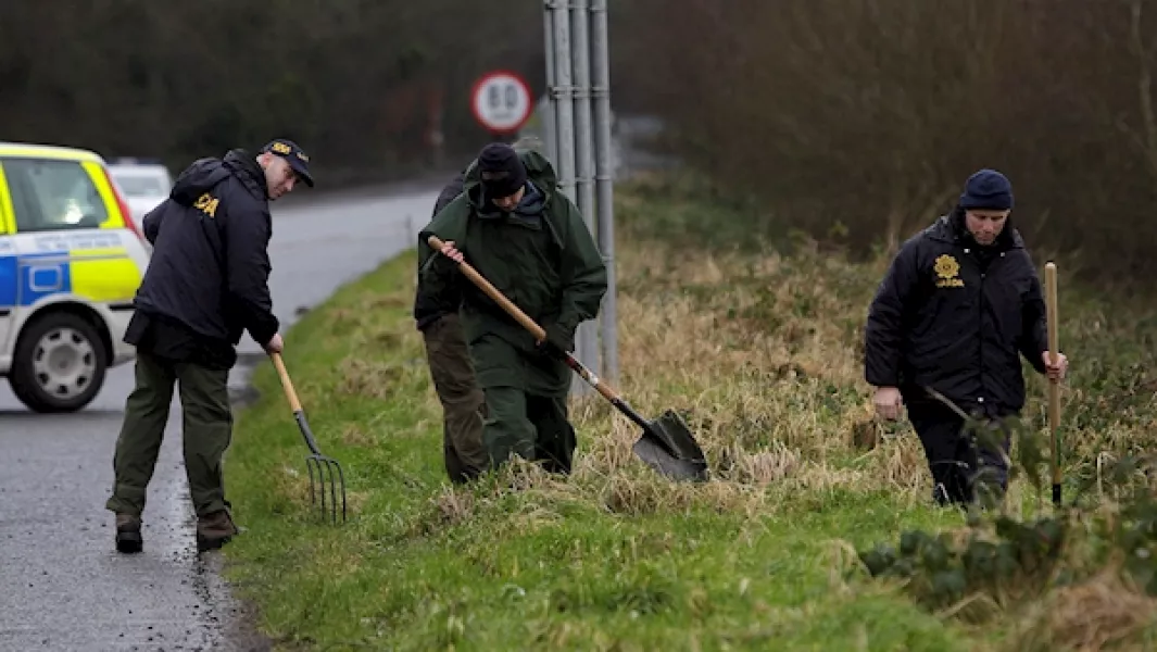 Gardai search of the roadside a short distance from the scene of the robbery and shooting