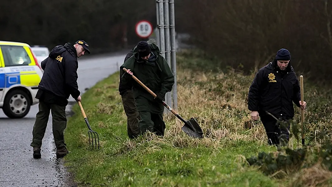 Gardai search of the roadside a short distance from the scene of the robbery and shooting