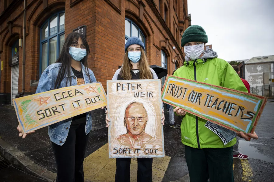 L-R Kylie McComb and Kathleen Malone both GSCE students from Belfast Royal Academy, with A level Ruben Hughes from St Malachy’s College Belfast show their homemade signs during a protest (Liam McBurney/PA)