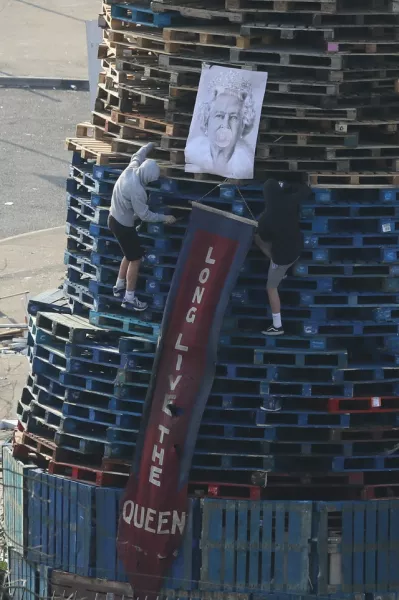 An image of the Queen is added to a bonfire in the Bogside. Photo: Brian Lawless/PA