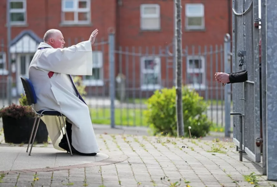 Father Paddy McCafferty hears a socially distanced confession in West Belfast during lockdown (Niall Carson/PA)