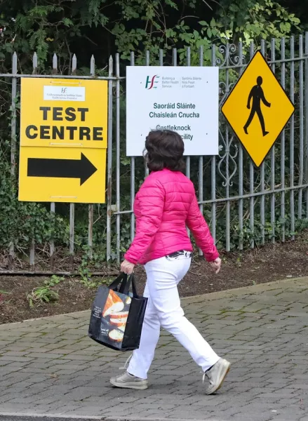A woman walks past one of two pop up Covid-19 testing facilities in Dublin at Castleknock Health centre (Niall Carson/PA)