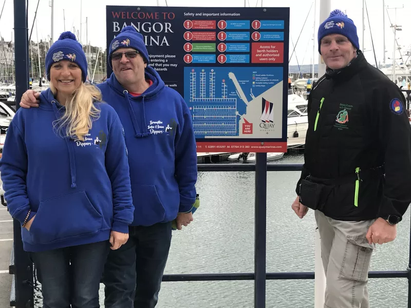 Sea swimmers Marie-Therese Davis Hanson and her husband Stephen Hanson welcome Henry O’Donnell to Bangor on his quest to swim around Ireland (Rebecca Black/PA)