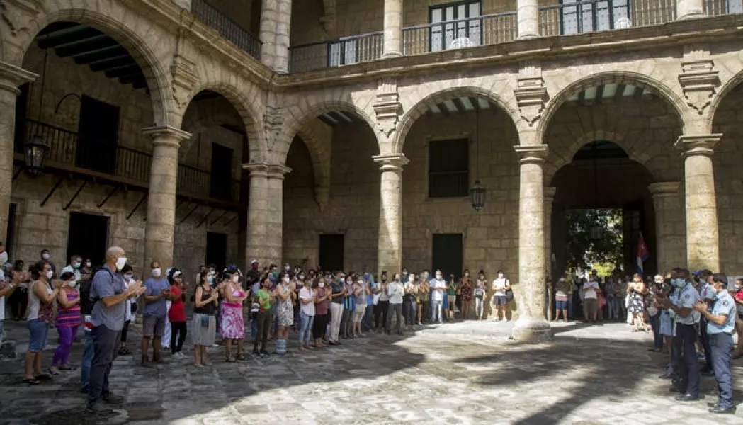 Office of the City Historian workers, wearing protective face masks as a precaution against the spread of Covid-19, gather at the Plaza de Armas to sing the National Anthem in a tribute to Eusebio Leal (Ismael Francisco/AP)