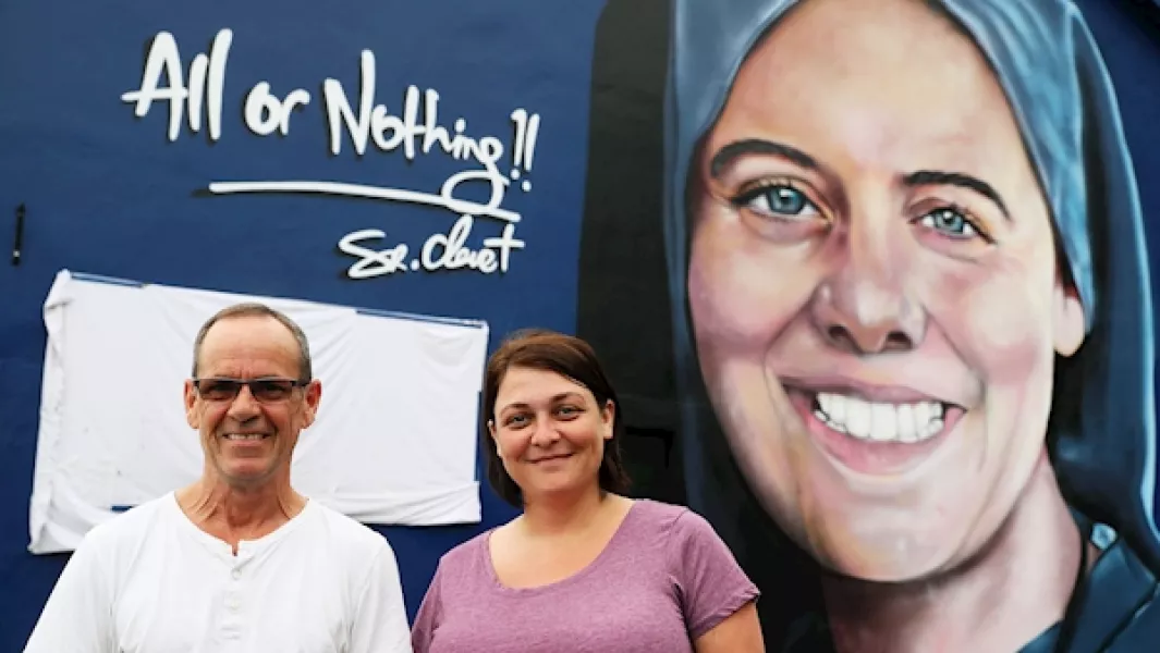 Megan Nicell, sister of Sister Clare Crockett, and Danny Doyle, godfather and uncle to the late nun, in front of a new mural of Sister Crockett ahead of a blessing service for the mural on Sunday evening. Photo: Brian Lawless/PA