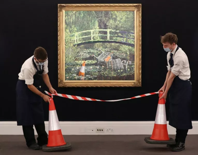 Two technicians with Banksy’s Show Me The Monet (Jonathan Brady/PA)
