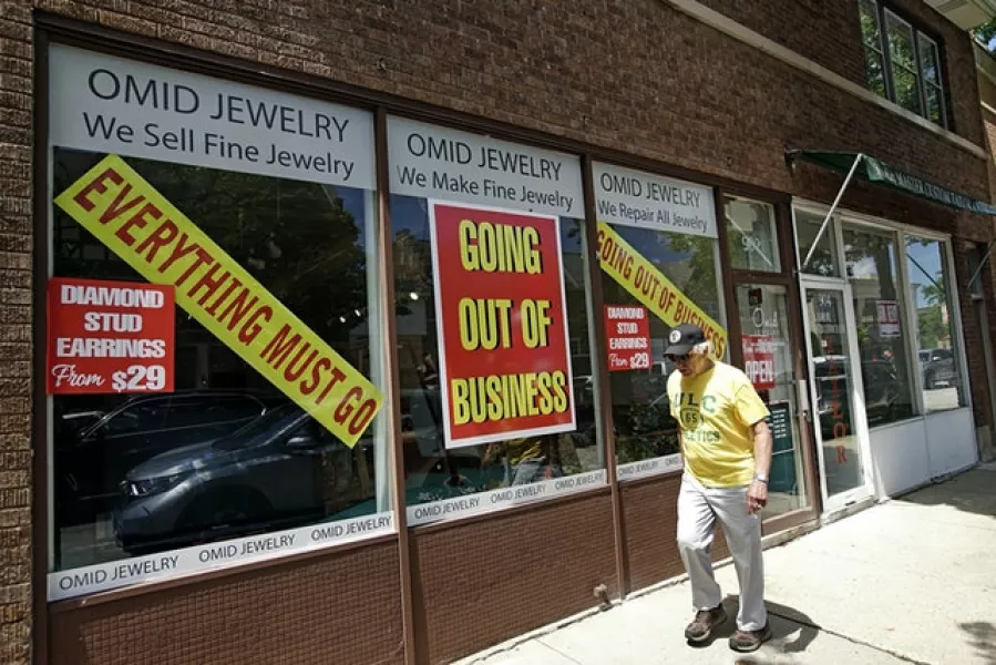 A man walks past a retail store that is going out of business due to the coronavirus pandemic in Illinois (AP/Nam Y. Huh)