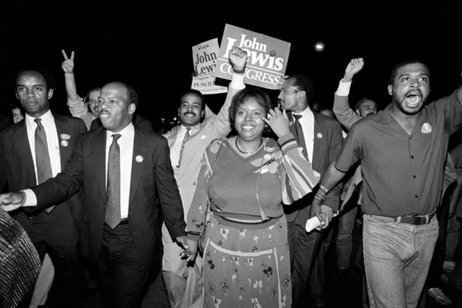 John Lewis, front left, and his wife Lillian lead a march of supporters from his campaign headquarters to an Atlanta hotel for a victory party after he defeated Julian Bond in a 1986 runoff election for Georgia’s 5th Congressional District seat in Atlanta (Linda Schaeffer/AP)