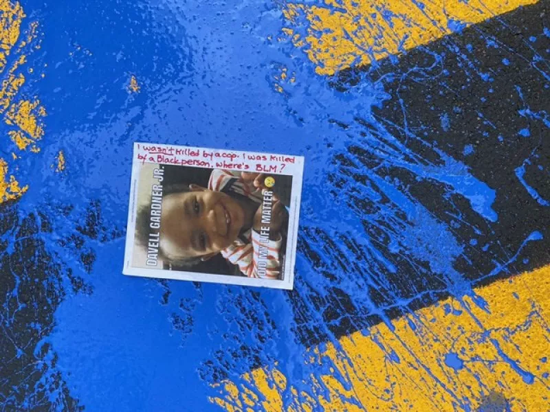 Blue paint and a flyer cover parts of the Black Lives Matter mural in front of Trump Tower (New York Police Department via AP)