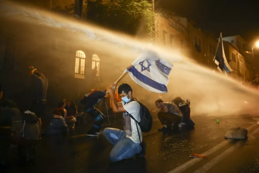 Israeli police use water cannon to disperse protesters (Oded Balilty/AP)