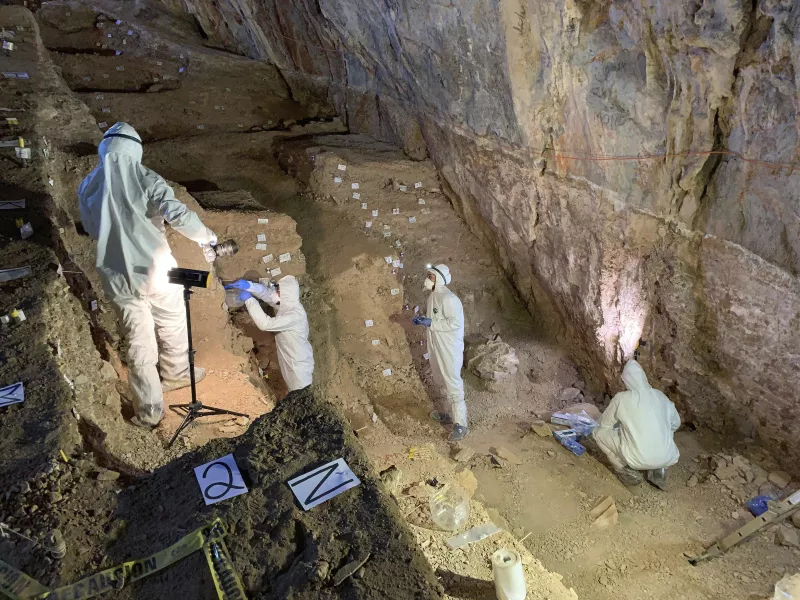 Researchers take samples in the cave (Mads Thomsen via AP)