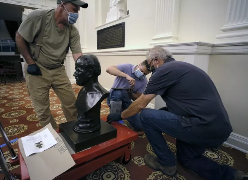 Workmen prepare to haul away a bust of Matthew Fontaine Maury (Bob Brown/PA)