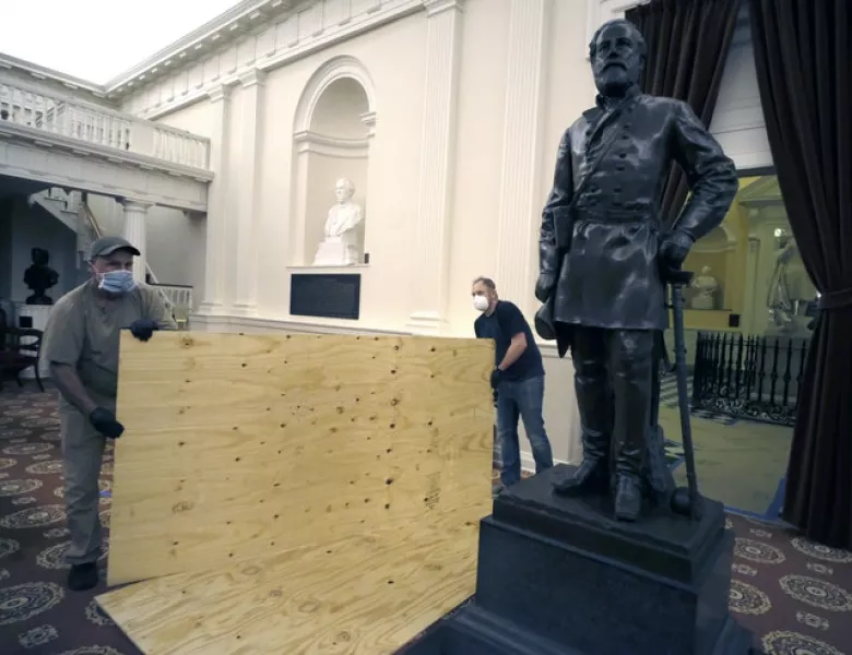 Workmen place plywood beside the statue of Robert E. Lee in the Old House Chambe (Bob Brown/PA)
