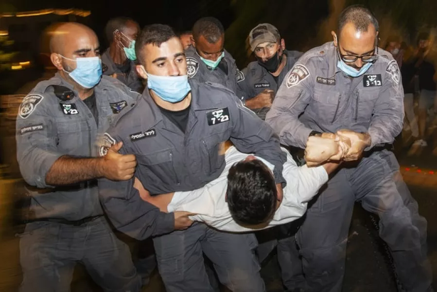 Israeli police officers arrest a demonstrator during a protest against Israel’s Prime Minister Benjamin Netanyahu outside his residence in Jerusalem (Ariel Schalit/AP)