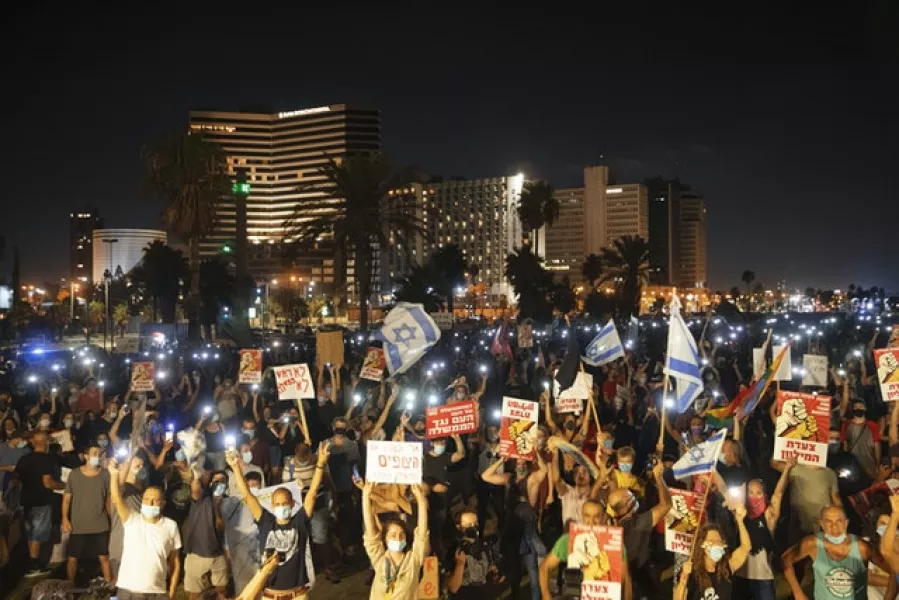 Protesters in Tel Aviv demanding the resignation Israel’s Prime Minister Benjamin Netanyahu as he faces trial on corruption charges and grapples with a deepening coronavirus crisis (Oded Balilty/AP)