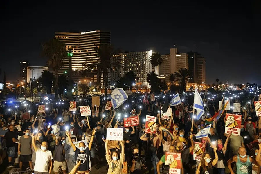 Protesters in Tel Aviv demanding the resignation Israel’s Prime Minister Benjamin Netanyahu as he faces trial on corruption charges and grapples with a deepening coronavirus crisis (Oded Balilty/AP)