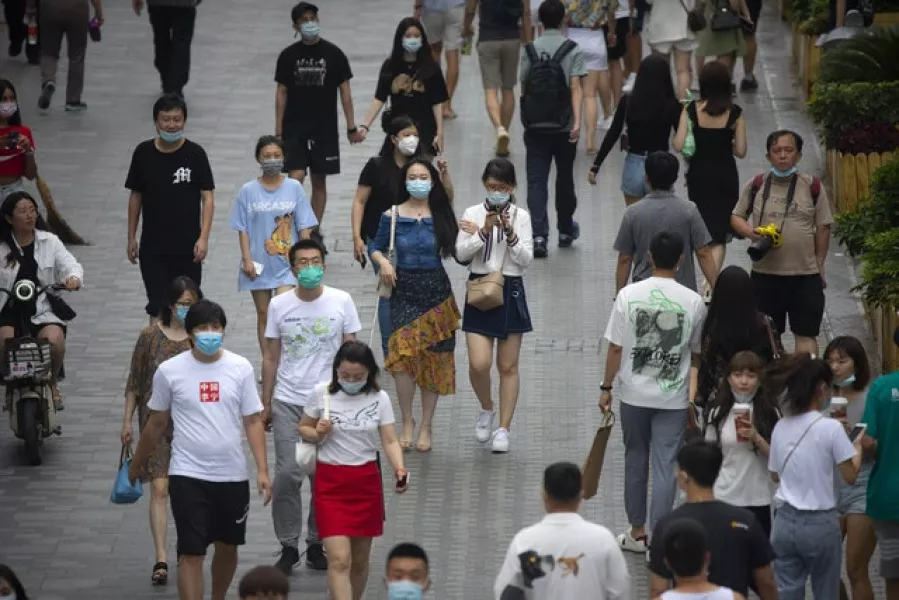 People at an outdoor shopping area in Beijing, as China reported several dozen new confirmed coronavirus cases (Mark Schiefelbein/AP)