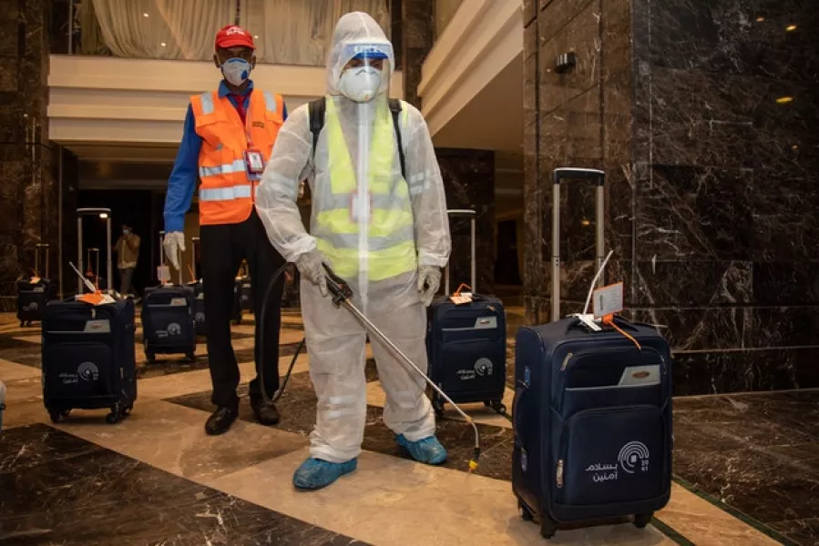 The luggage of pilgrims is sanitised in a hotel lobby in Mecca (Ministry of Media/AP)