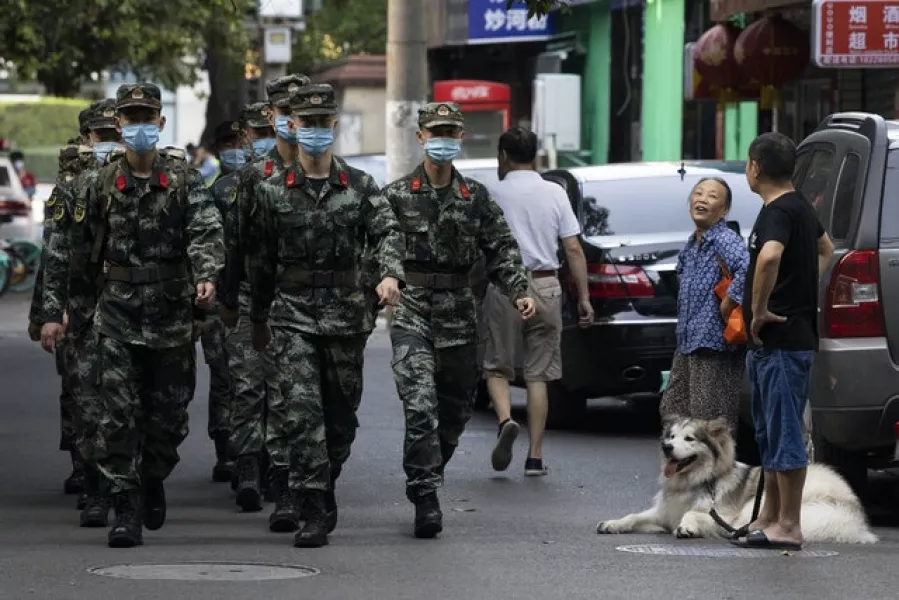 Chinese paramilitary policemen march near a neighborhood sealed off before the official closure of the US consulate in Chengdu (Ng Han Guan/AP)
