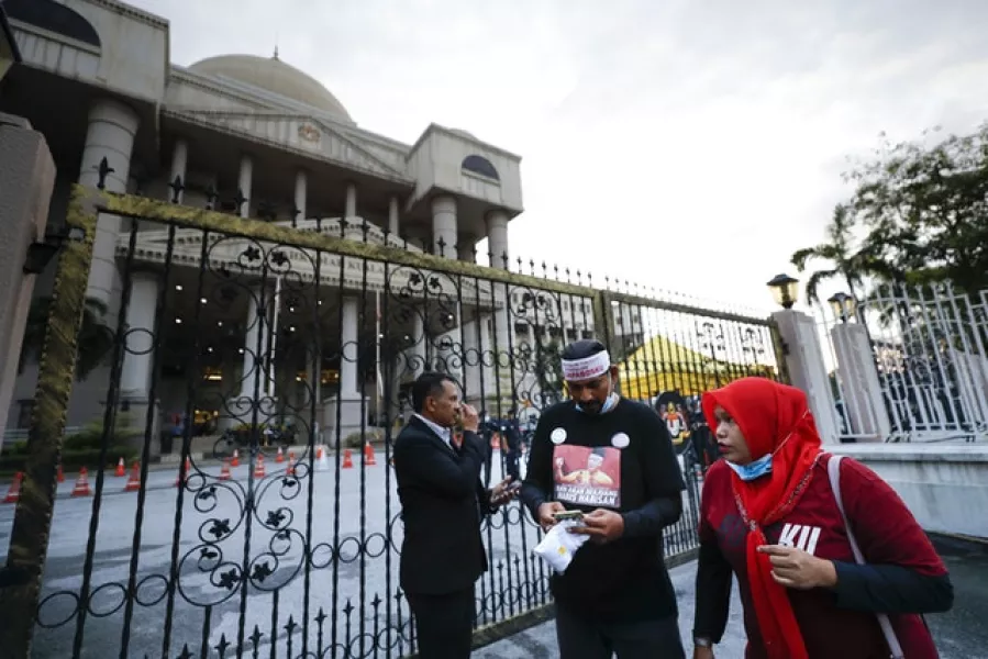 Supporters of Najib wait outside court (Vincent Thian/AP)