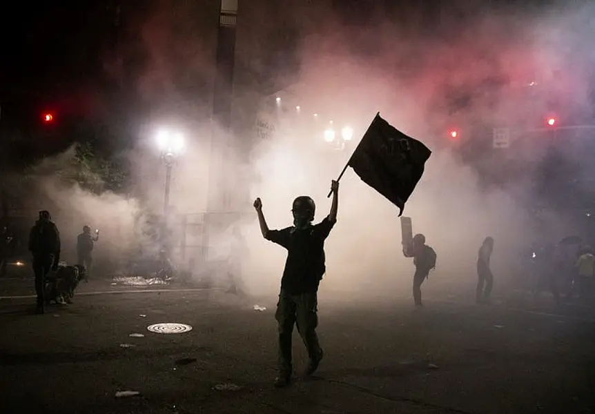 Tear gas is released during late night protests in Portland (Beth Nakamura /The Oregonian via AP)