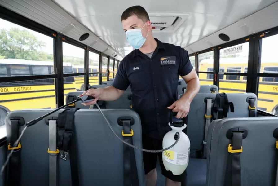Des Moines Public Schools mechanic Kelly Silver cleans the interior of a school bus in Iowa (AP)