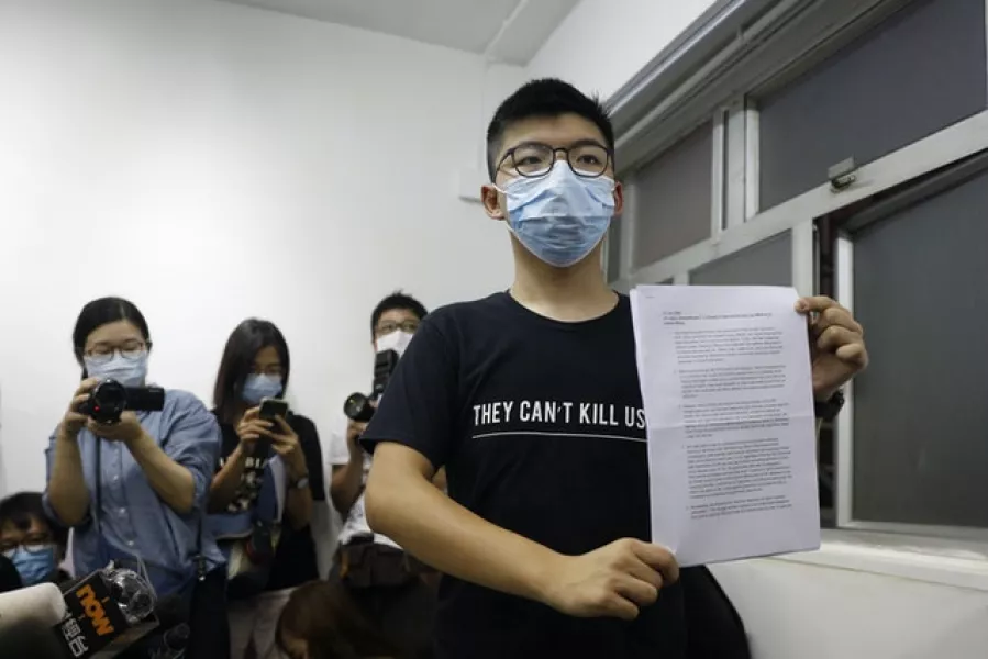 Hong Kong pro-democracy activist Joshua Wong shows his disqualification notice during a press conference (Kin Cheung/AP)