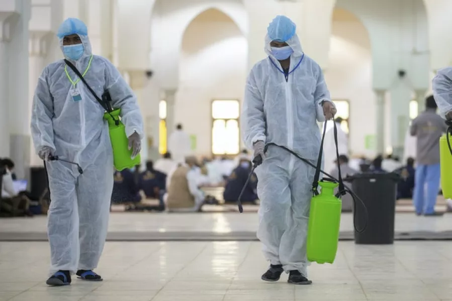 Health officials spray disinfectant (Saudi Ministry of Media via AP)