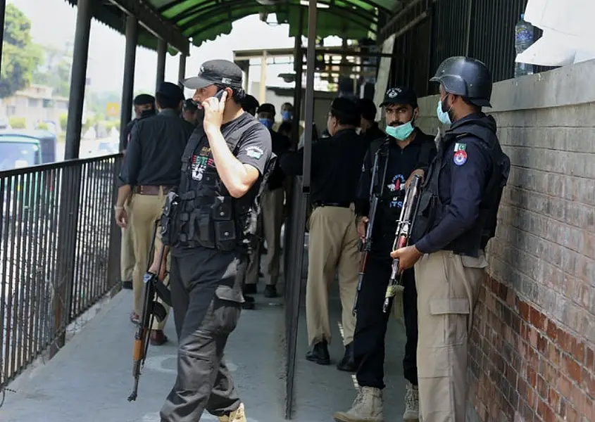 Police officers gather at an entry gate of the district court (AP/Muhammad Sajjad)