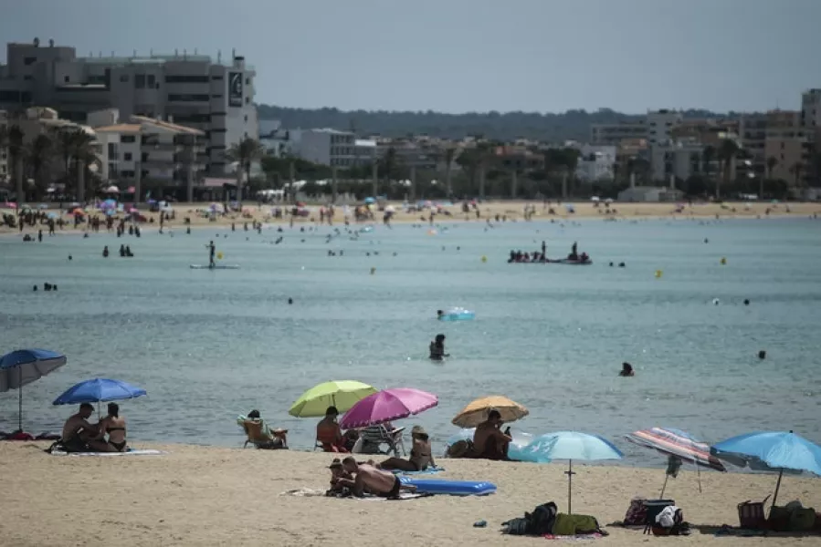 Sunbathers enjoy the beach in the Balearic Islands capital of Mallorca. Photo: AP/Joan Mateu