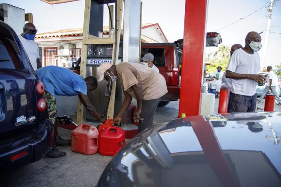 Residents fill their containers with petrol at Cooper’s petrol station before the arrival of Hurricane Isaias in Freeport, Grand Bahama, Bahamas (Tim Aylen/AP)