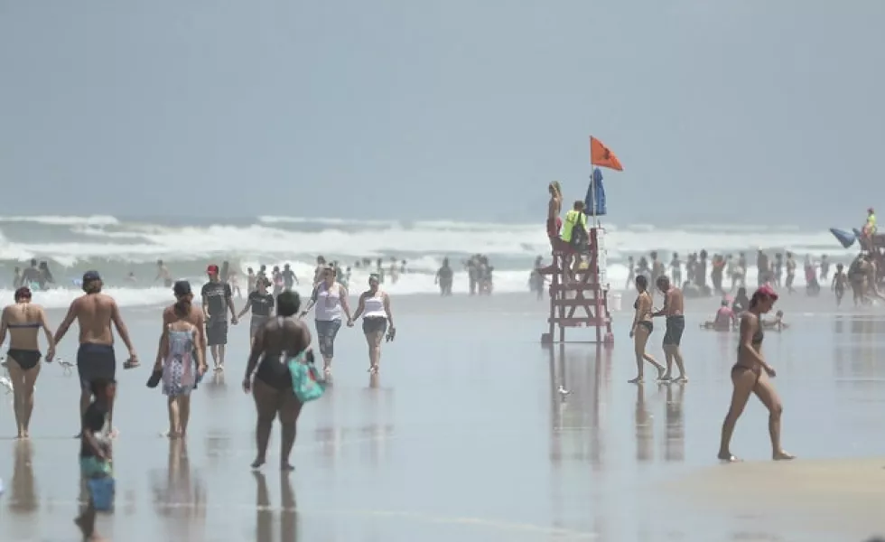 People brave the winds at Daytona Beach, Florida (Stephen M. Dowell/Orlando Sentinel via AP)