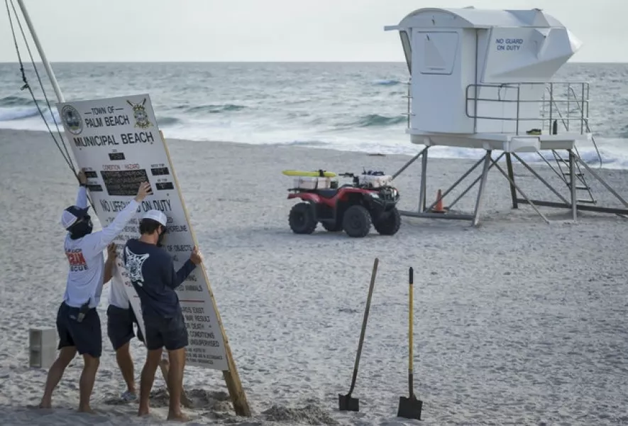 Palm Beach Ocean Rescue personnel take down the weather conditions signage in preparation for Hurricane Isaias (Thomas Cordy/The Palm Beach Post via AP)