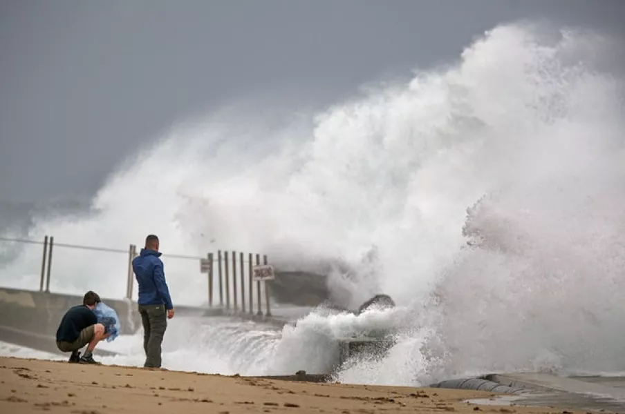 Waves driven by Tropical Storm Isaias crash over the jetty on the north side of the Palm Beach Inlet (Lannis Waters/The Palm Beach Post?AP)